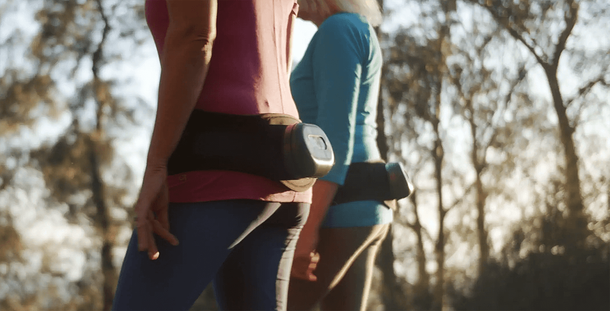 Two women walking in the woods wearing Osteoboost