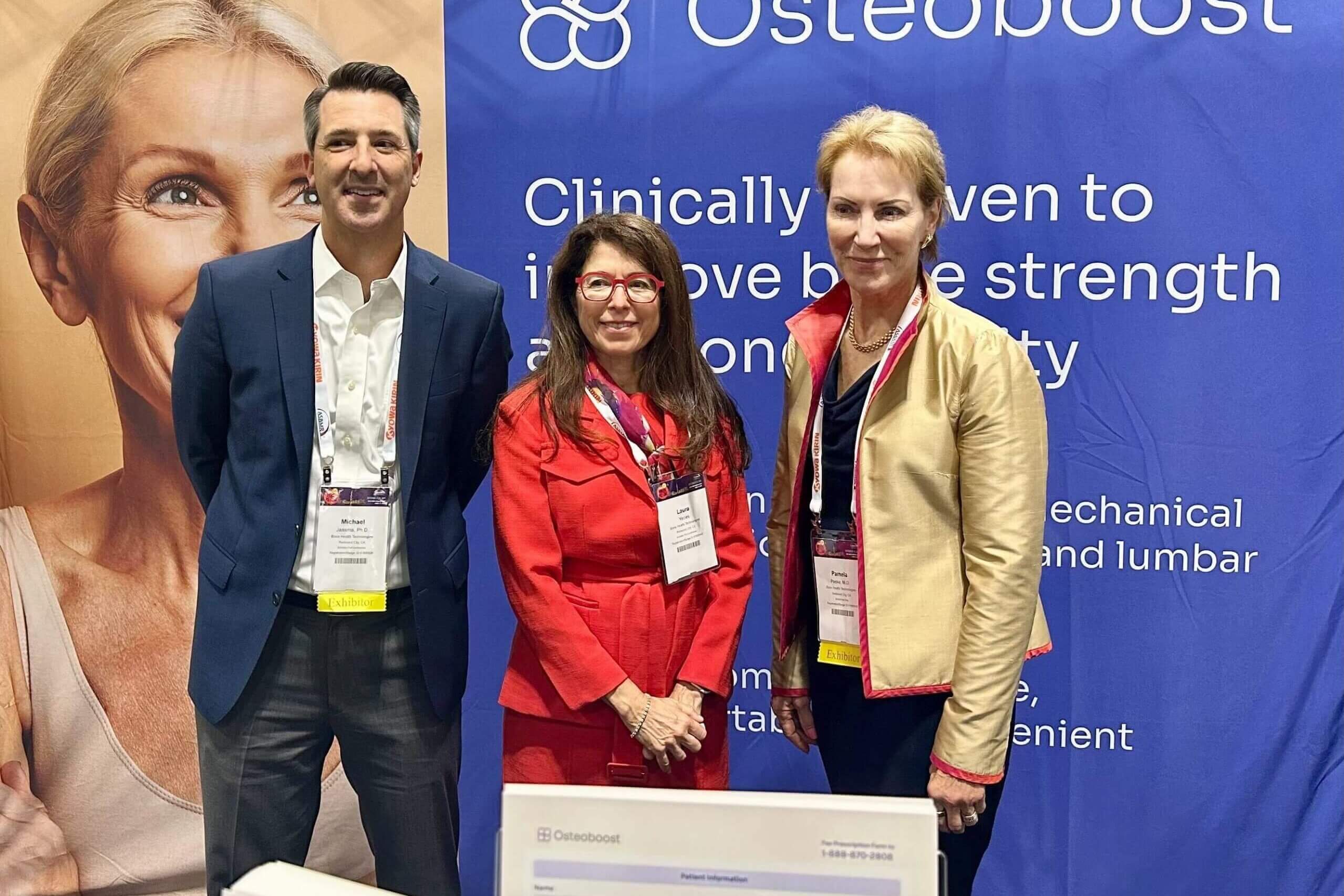 Michael Jaasma, Laura Yecies, and Dr. Pamela Peeke stand in front of an Osteoboost banner